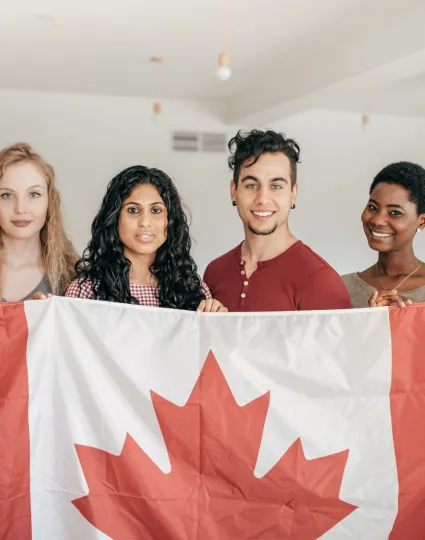4 people holding a Canadian flag.